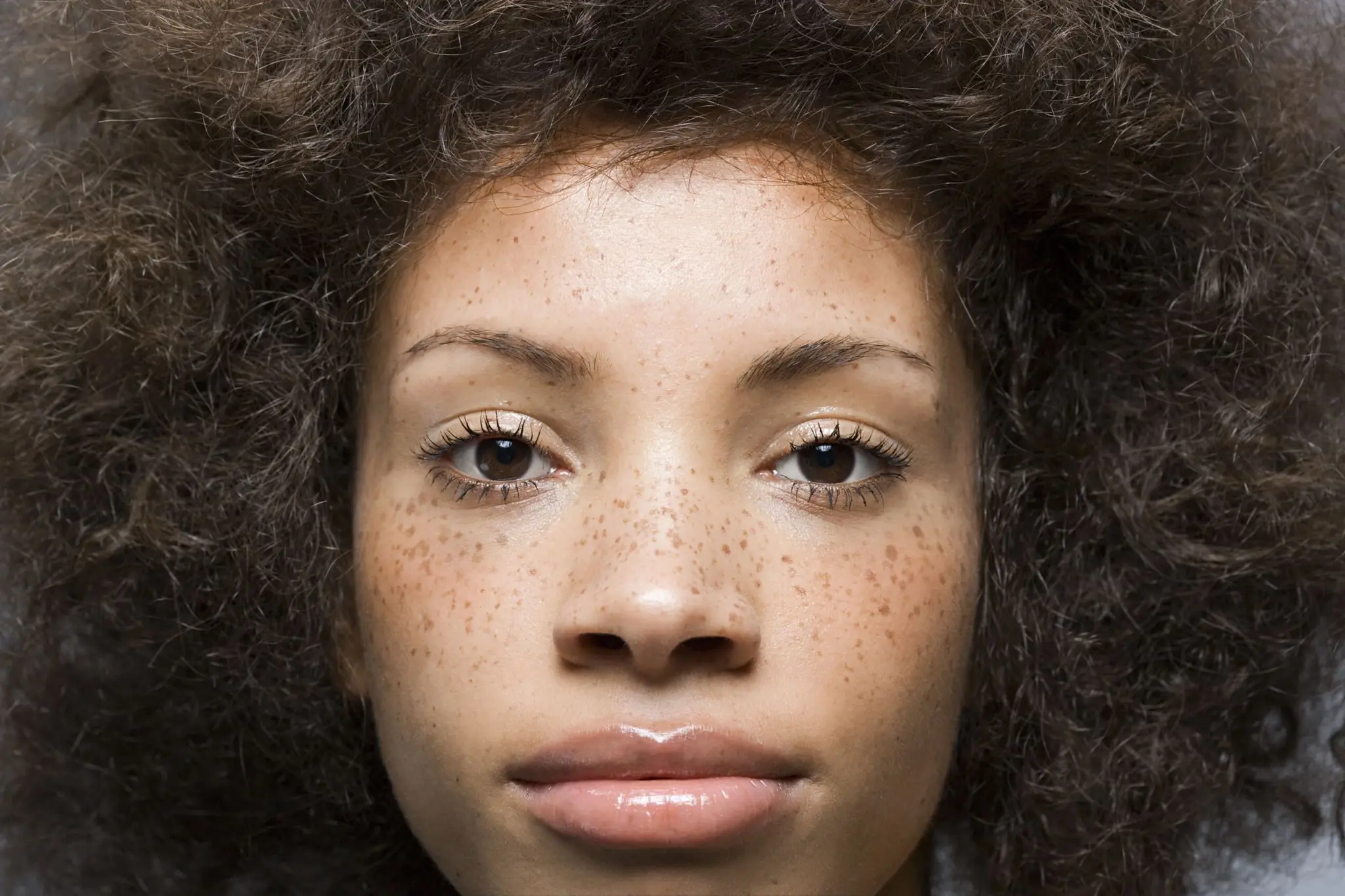 Person with curly hair and freckles, close-up.