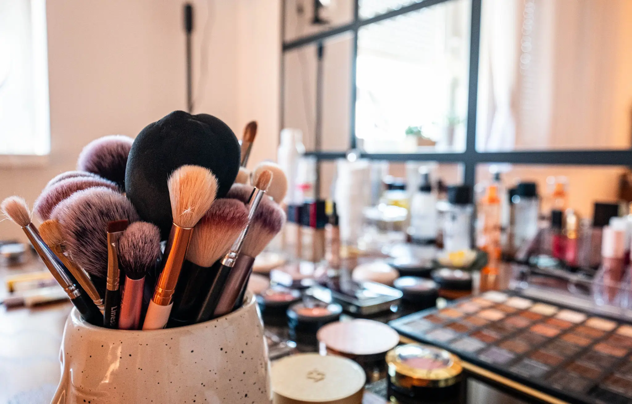 Makeup brushes and cosmetics on a table.