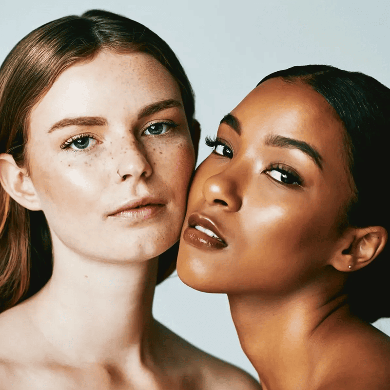 Two women posing with natural makeup.