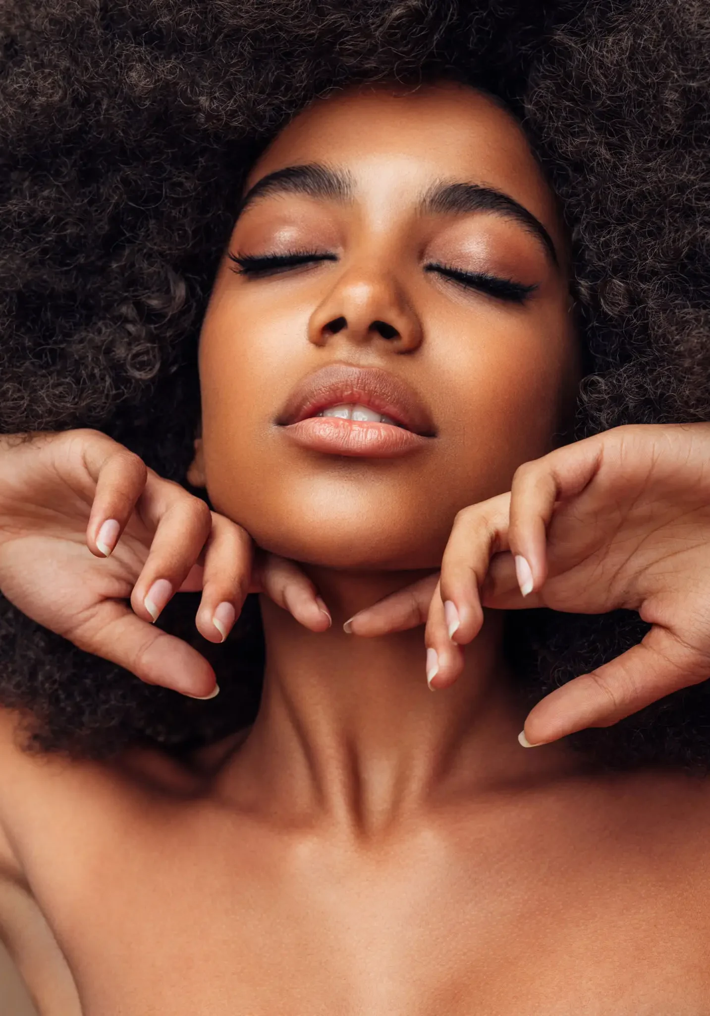 Woman with closed eyes and curly hair.
