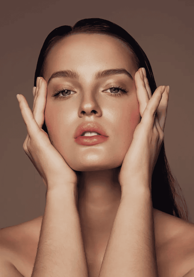 Woman posing with hands on face.